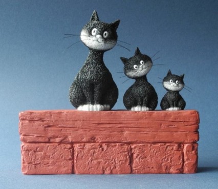 3 Poezen Dubout op een muurtje.